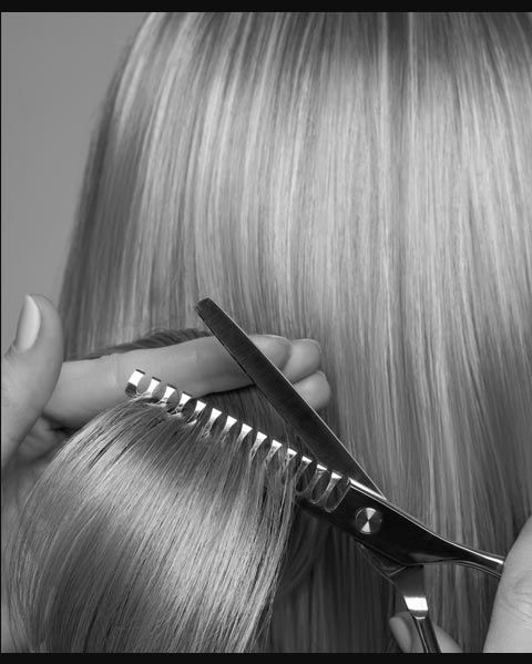 close up of scissors cutting hair